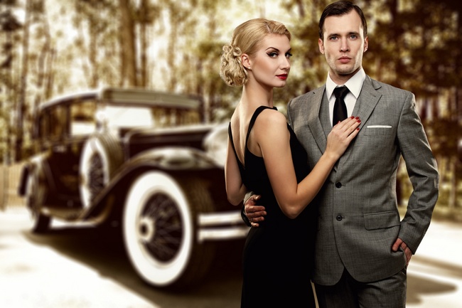 Retro couple against old car.